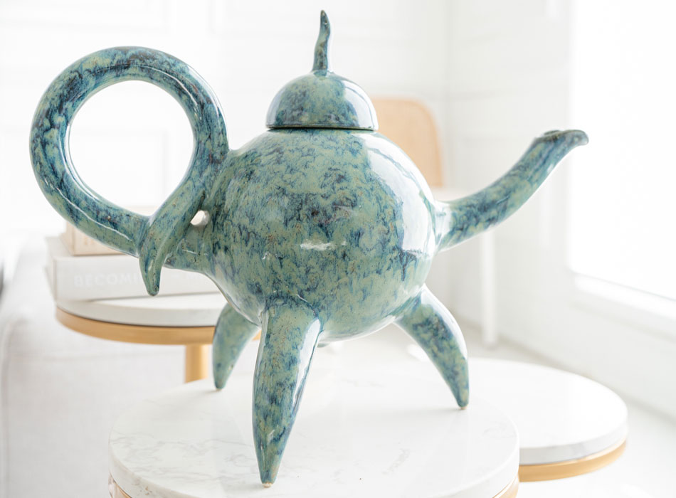 Turquois ceramic teapot with a curled handle