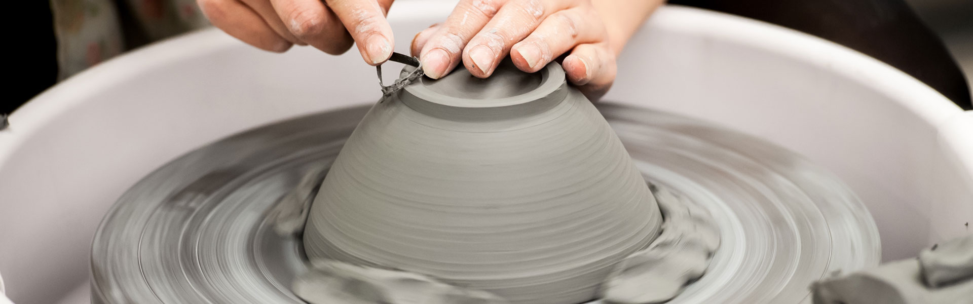Hands fashioning a bowl on the potter's wheel