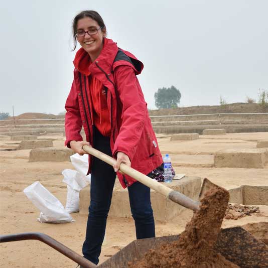 Dr. Anke Hein shoveling dirt at an archaeological site
