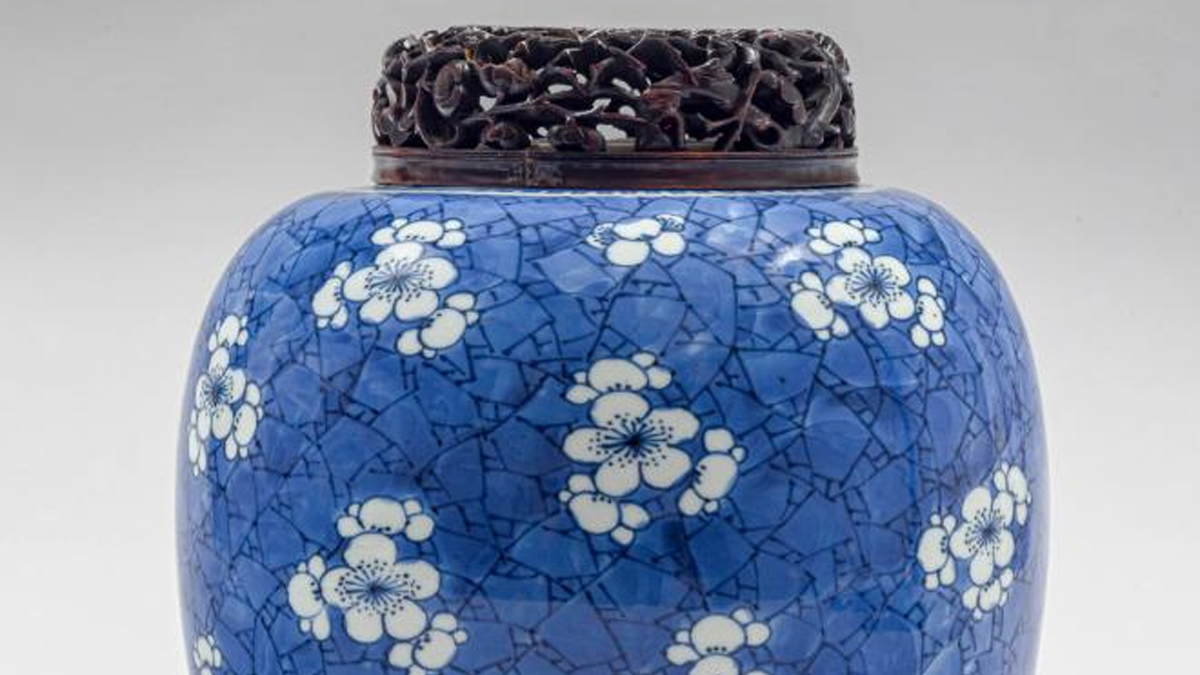 Blue ceramic jar with white flowers and a carved wood lid