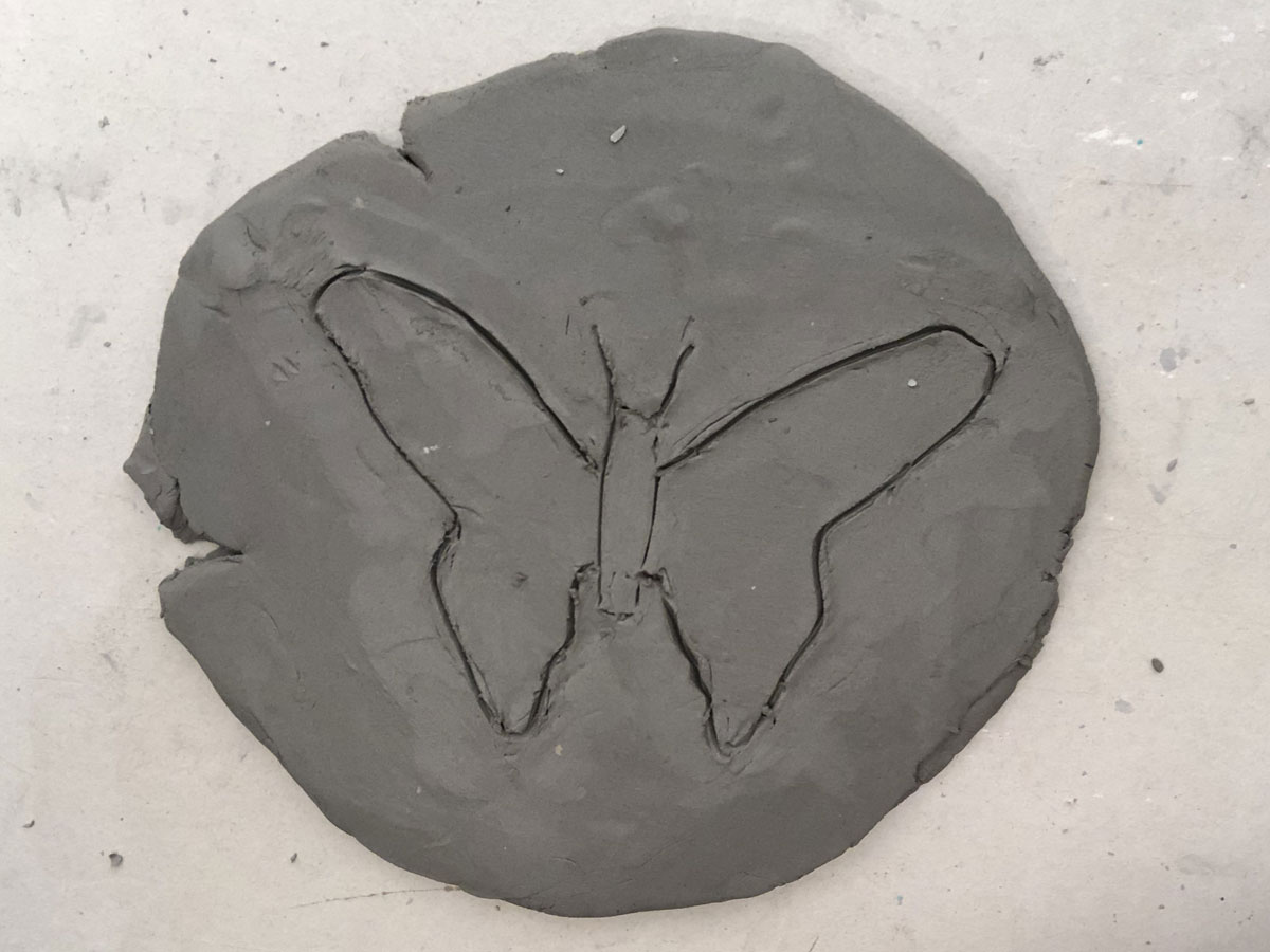 Slab of clay with the outline of a butterfly