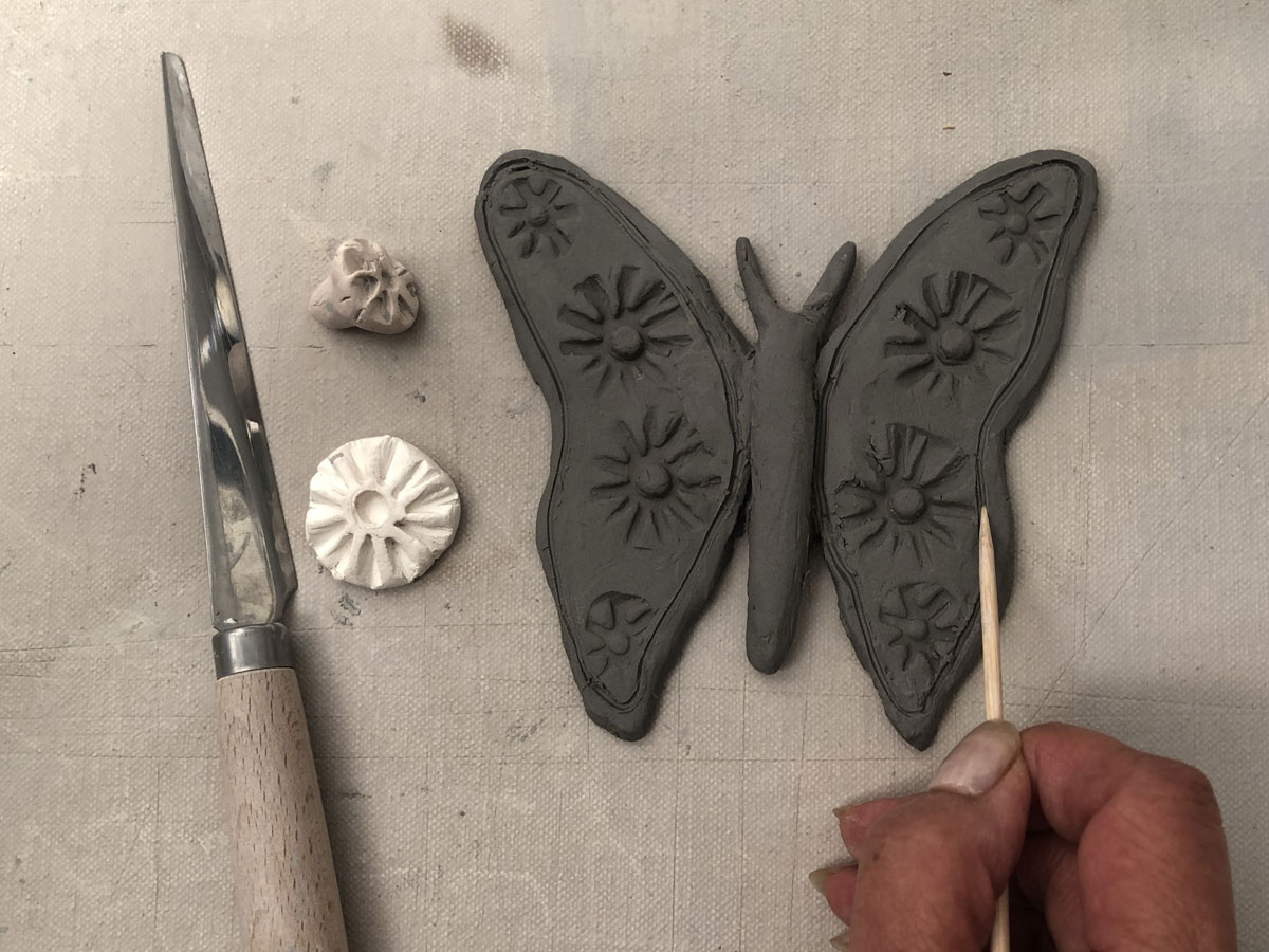 Decorating a clay butterfly