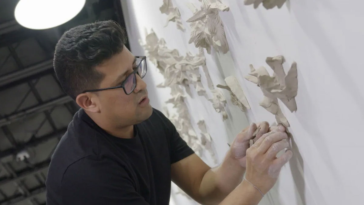 Artist David Salazar installing his ceramic birds