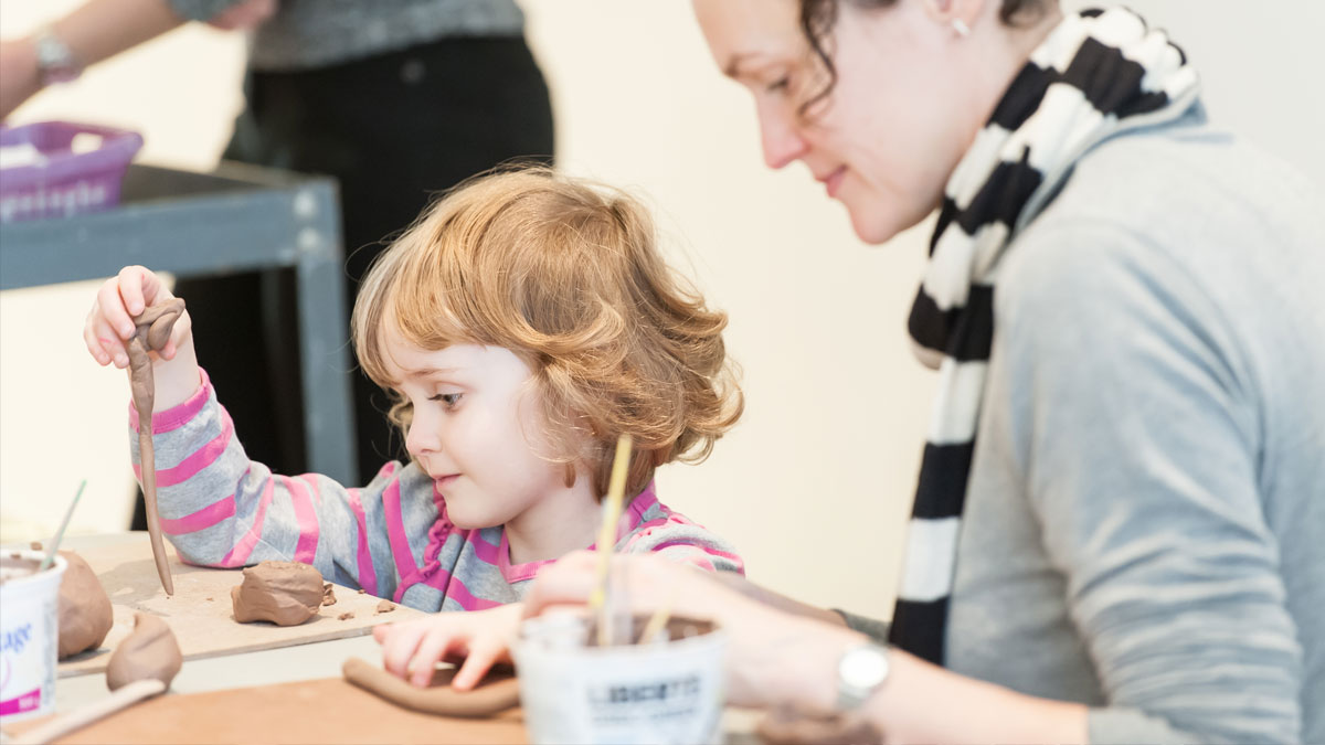 Mother and daughter at a table making ceramics