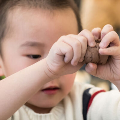 Child squeezing a ball of clay