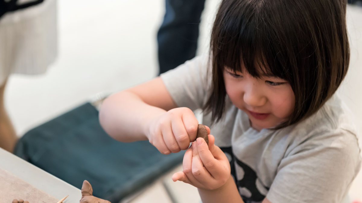Child shaping a clay object