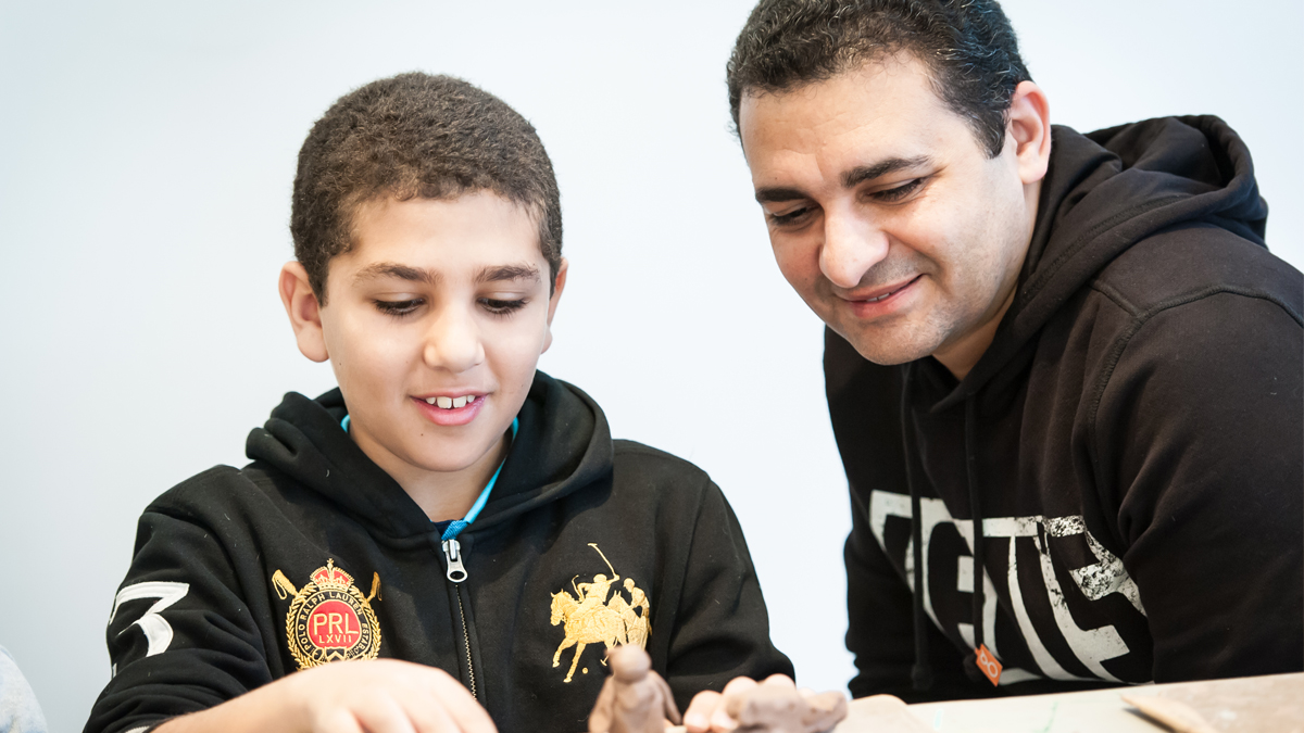 A boy and his father sculpting objects with clay