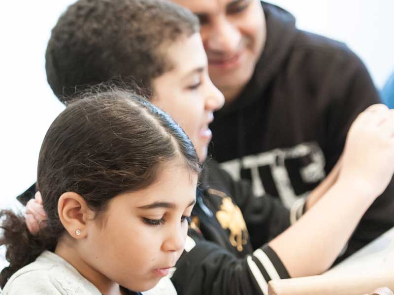 A father and two children doing an art activity