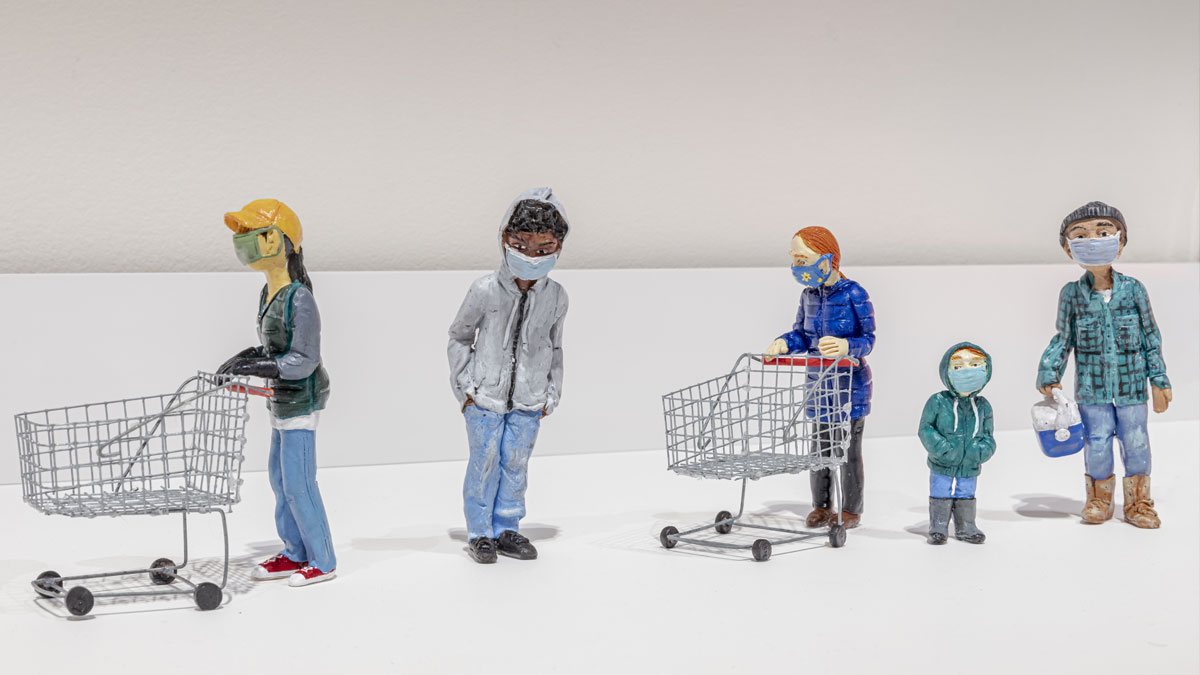 A line up of small clay figures wearing masks and pushing shopping carts
