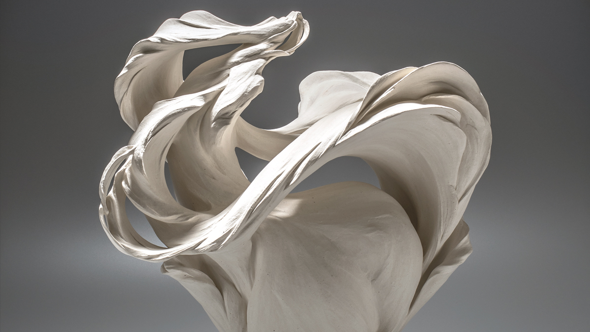 A white ceramic sculpture with a flowing silhouette