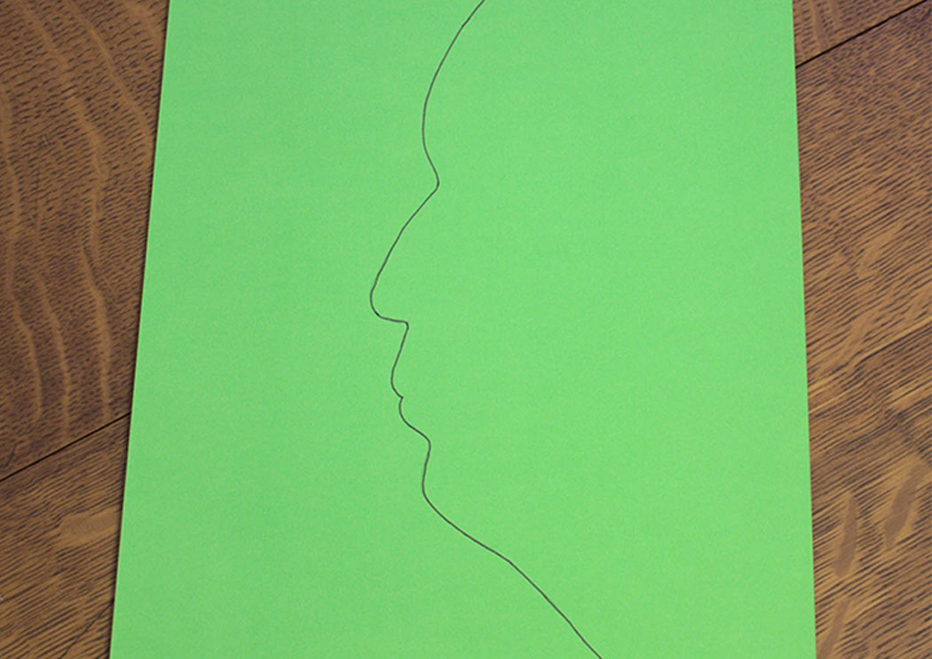Pencil silhouette on a green piece of paper