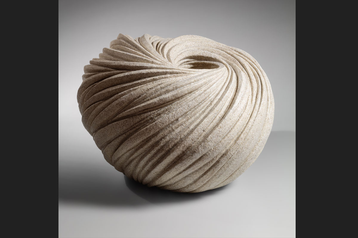Ceramic sculpture in the form of a sphere with the sides gathering toward a hole in the middle