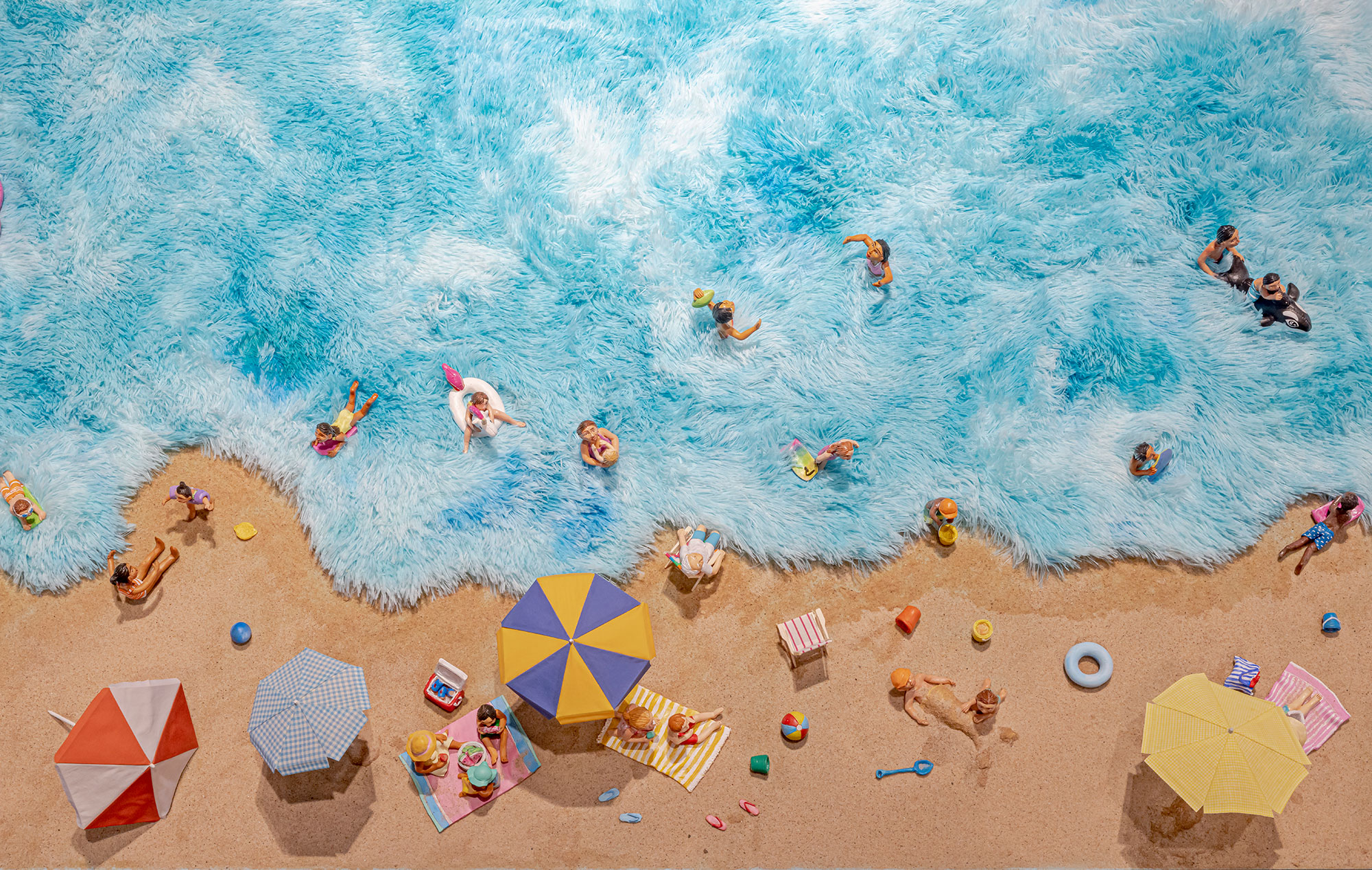 Miniature polymer clay figures arranged in a beach scene