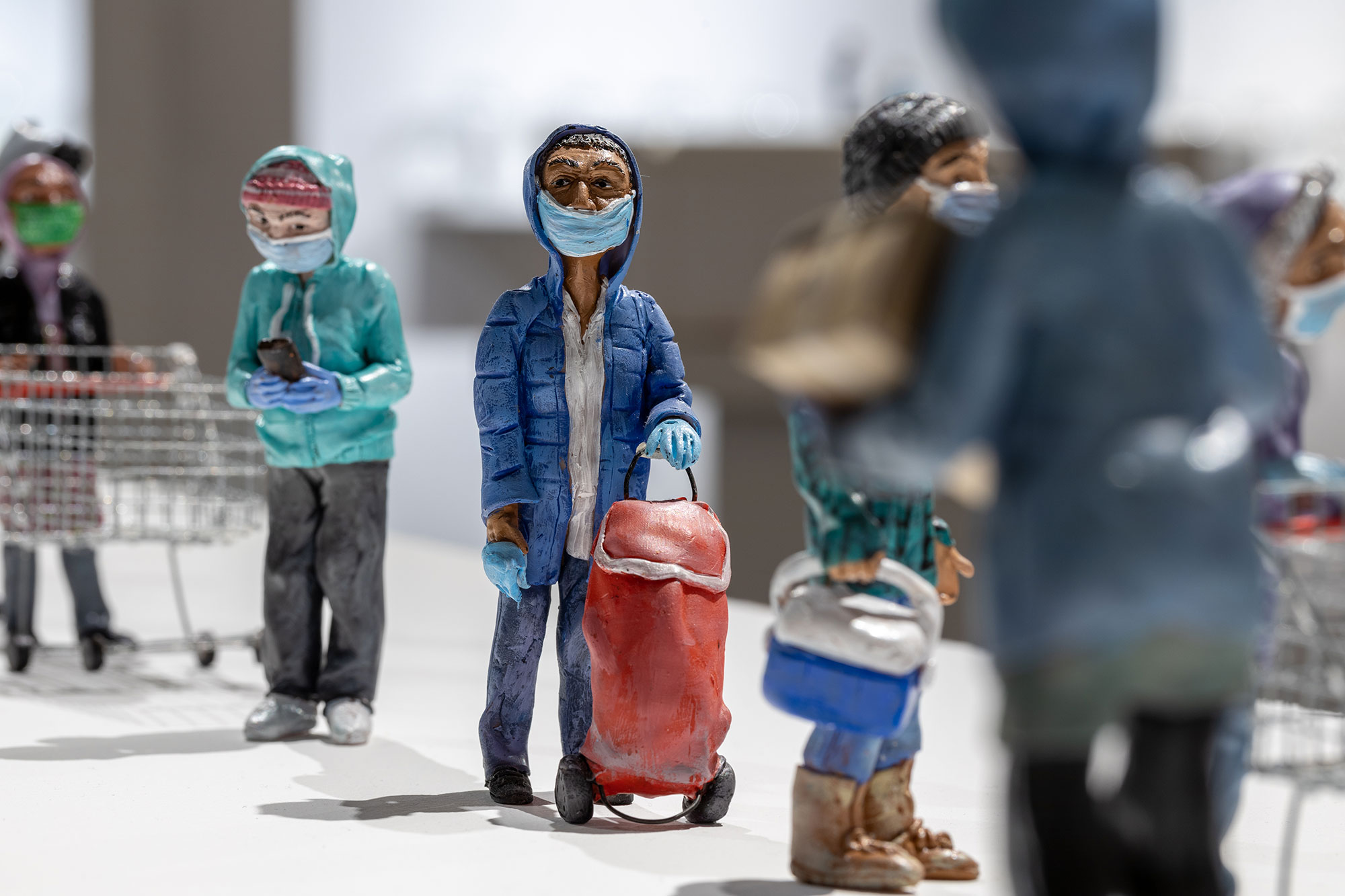 Masked polymer clay figures in a food bank line up