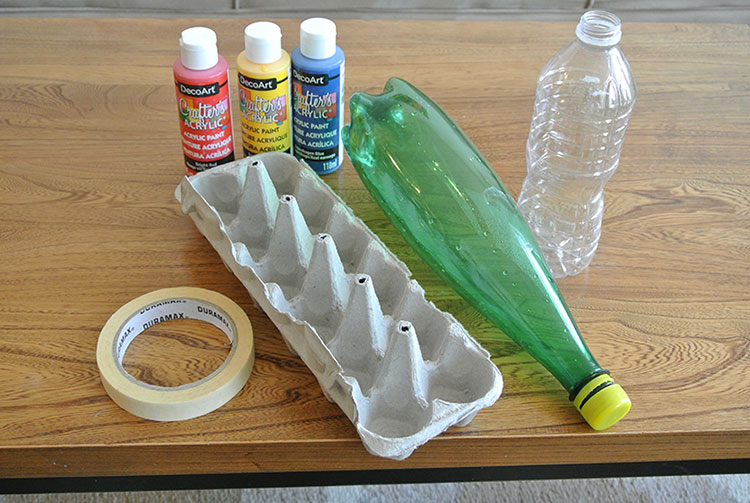 Paint, tape, egg carton, and plastic bottles on a table