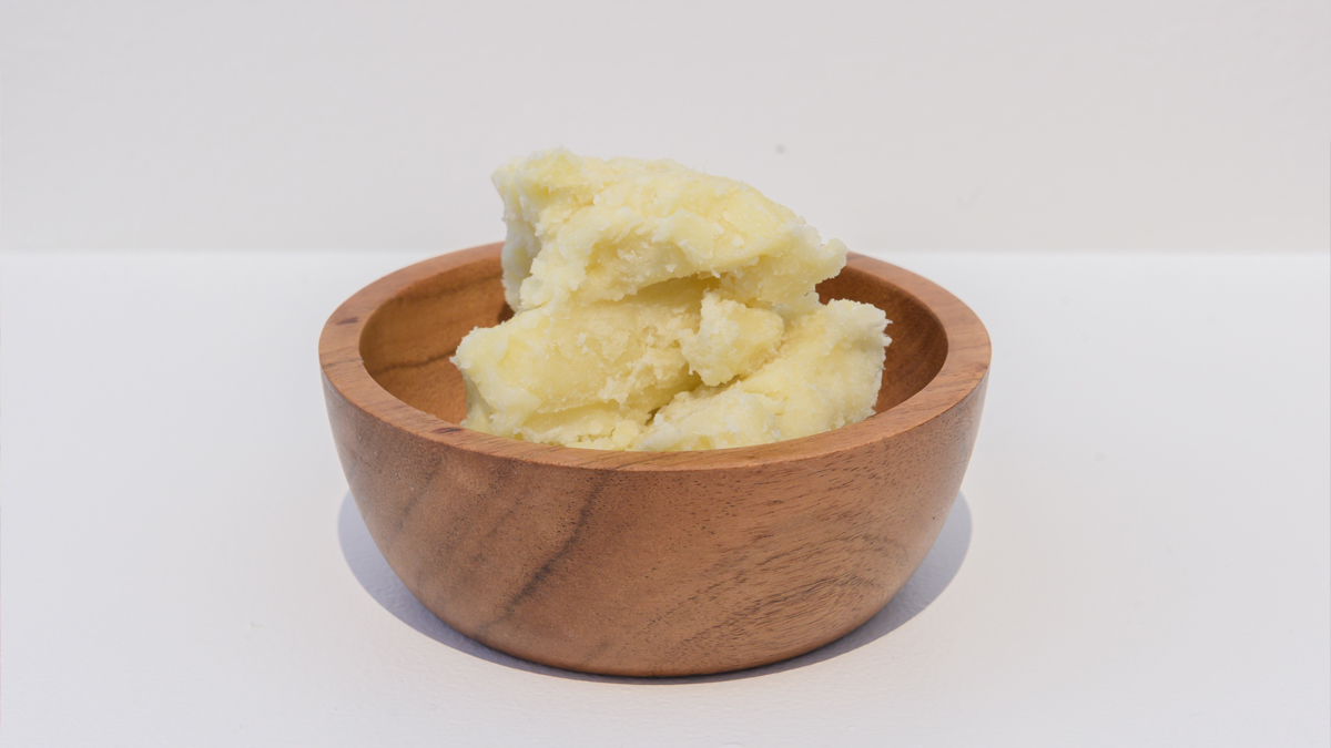 Shea butter in wood bowl displayed in the exhibition Hair We Are