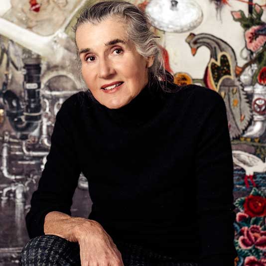 Artist Natalka Husar wearing a black turtleneck and leaning her arm on her leg