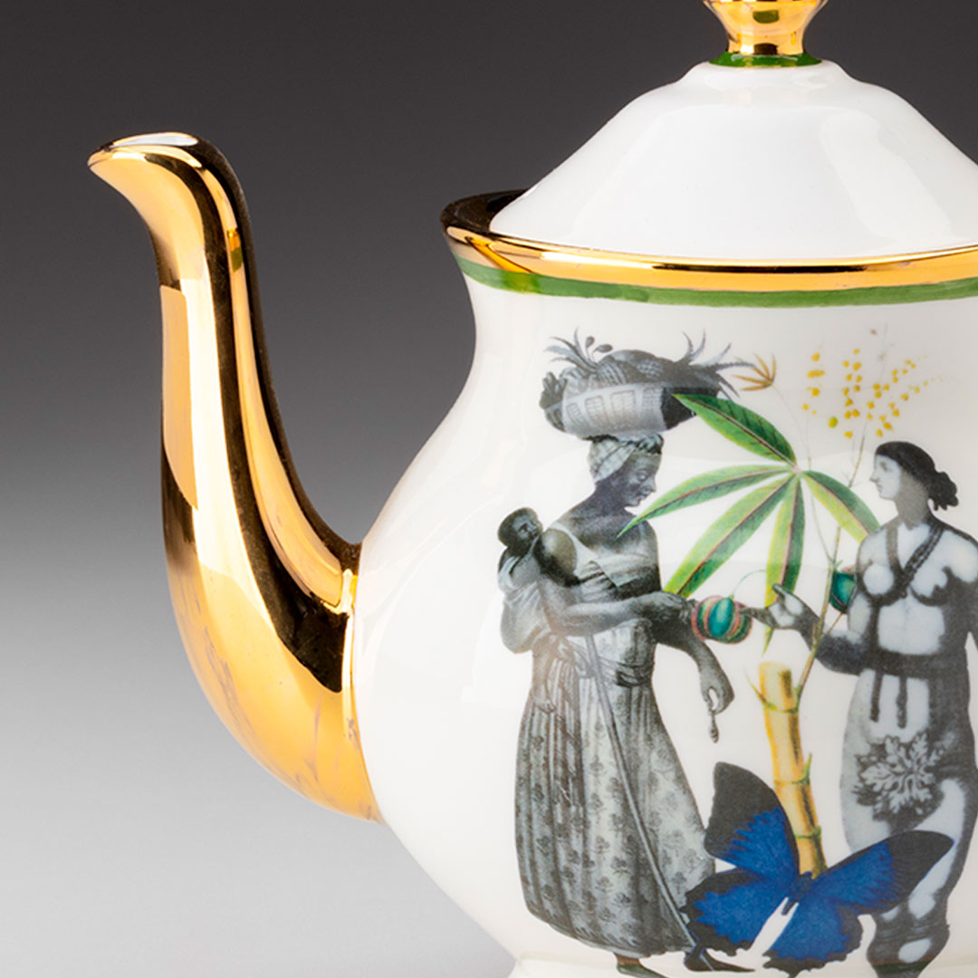 A teapot with a gold spout and a scene of people in the Caribbean