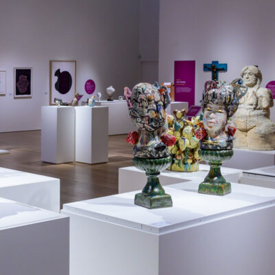 A grouping of ceramic artworks displayed on white plinths
