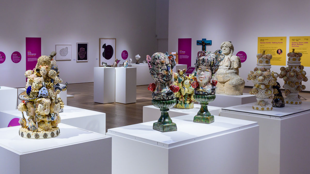 A grouping of ceramic artworks displayed on white plinths