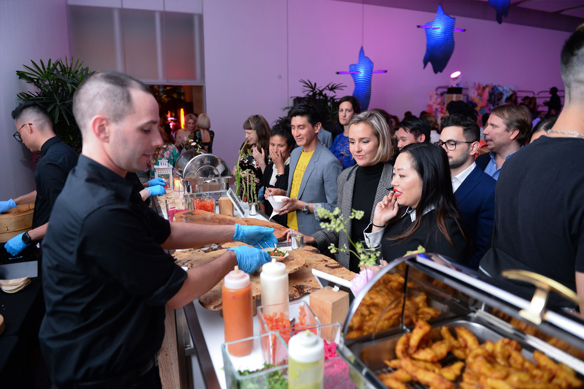 A group of party guests lined up at a food station