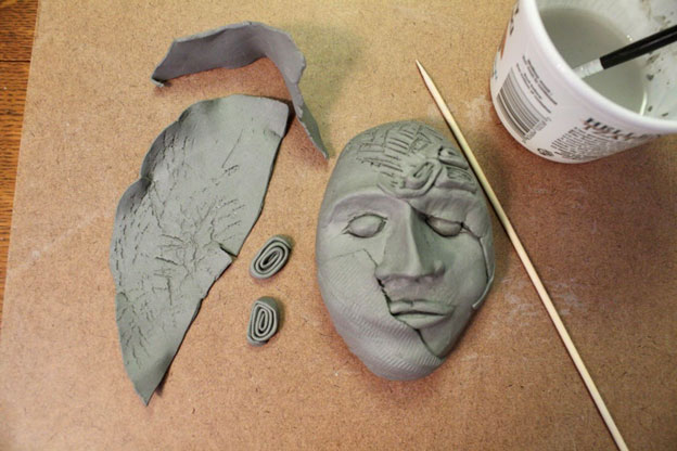 Clay face with pieces to stick on