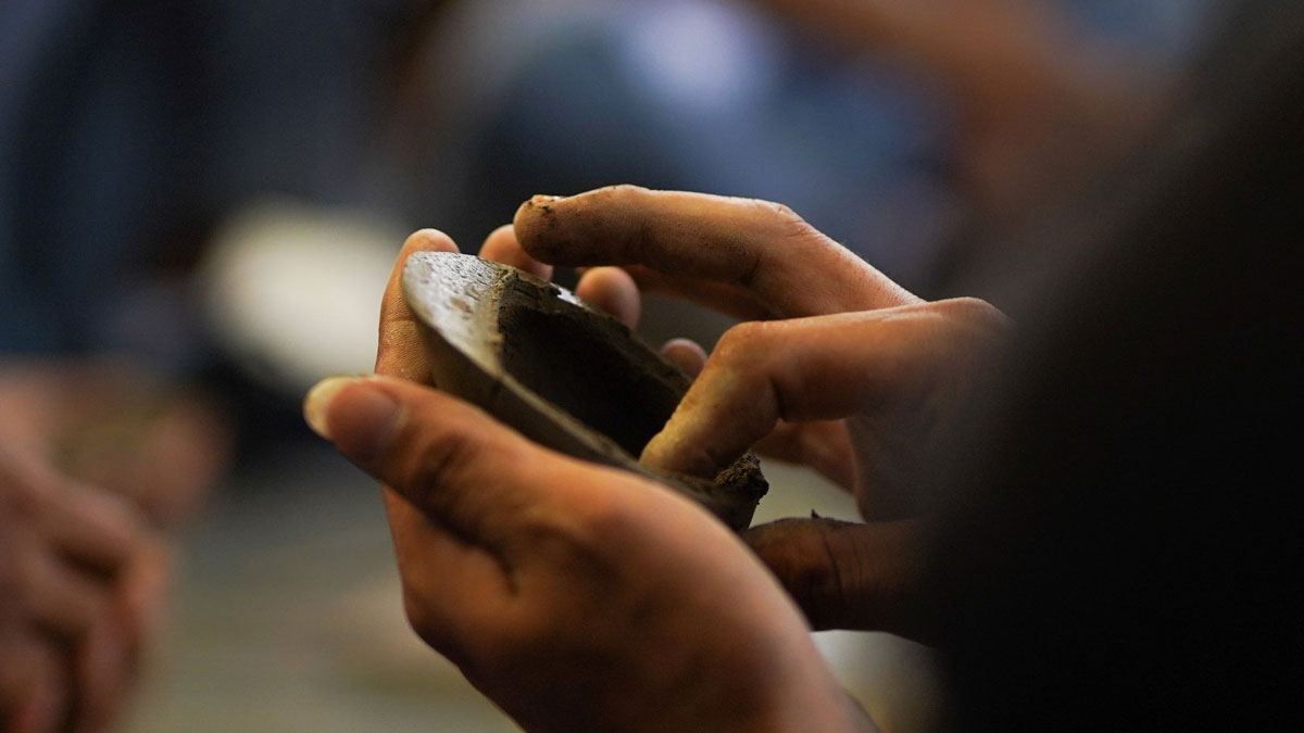 Hands of someone making an instrument out of clay