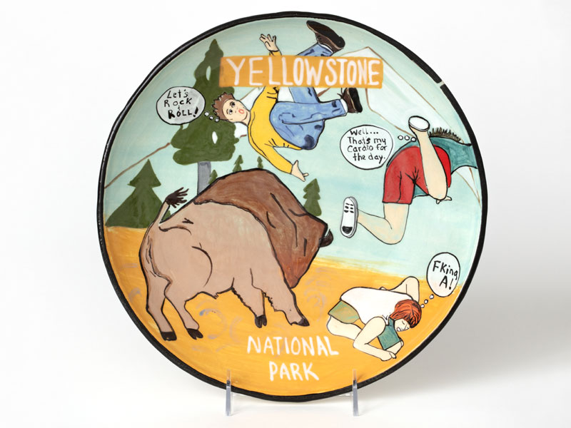 A plate with a scene of tourists being thrown in the air by a buffalo