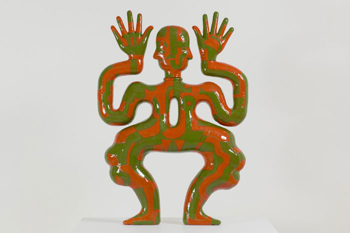 Green and red ceramic figure with wavy limbs