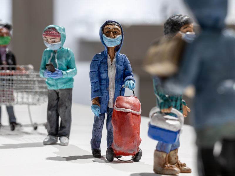 Masked polymer clay figures in a food bank line up