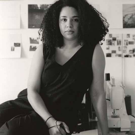 Artist Mallory Lowe Mpoka in a black and white photo in her studio