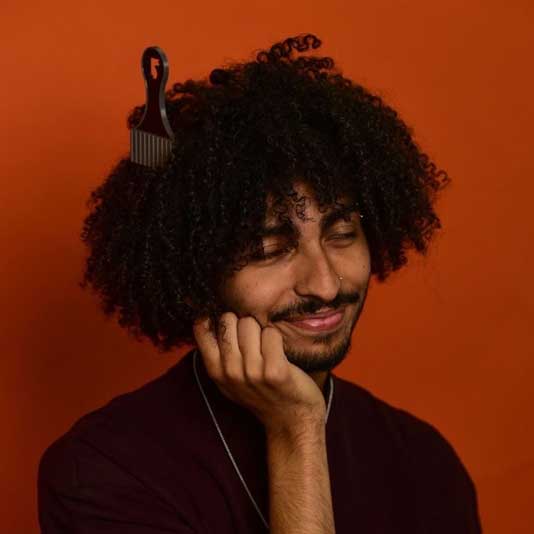 Martin Gomes wearing a black shirt in front of a red backdrop