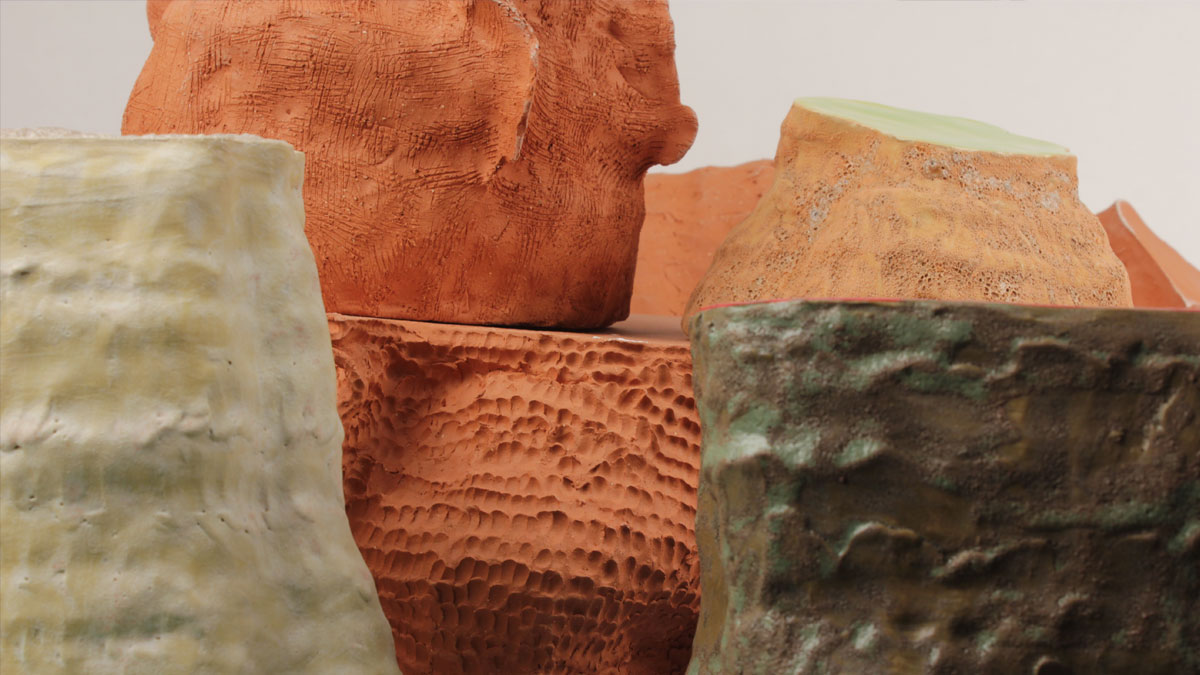 A collection of different size pottery vessels in terracotta and green tones