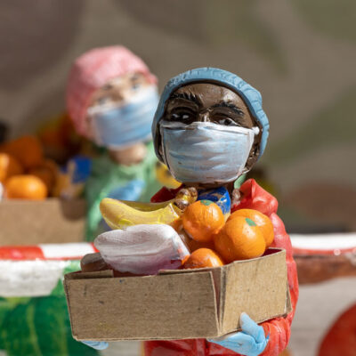 Miniature figure at a food bank holding a box of food