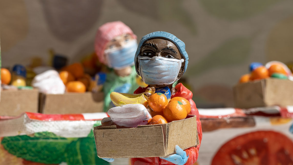 Miniature figure at a food bank holding a box of food