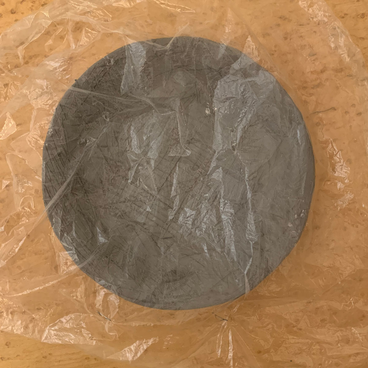 Round clay slab covered with plastic