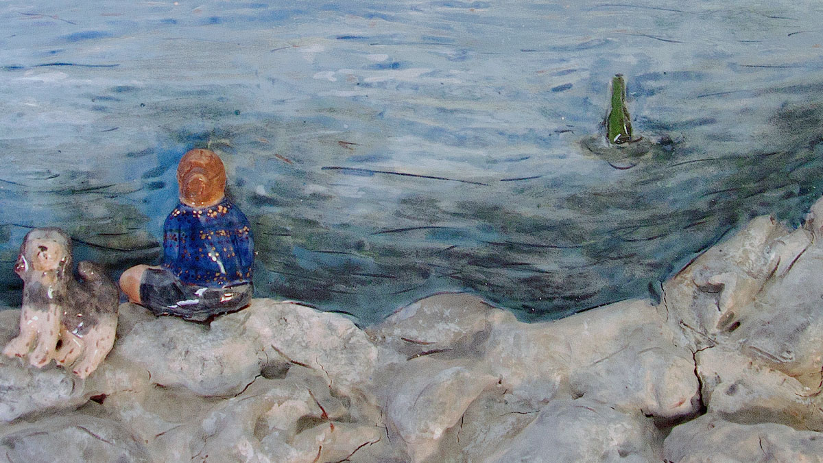 Detail of a plate painted with a figure sitting by the lake