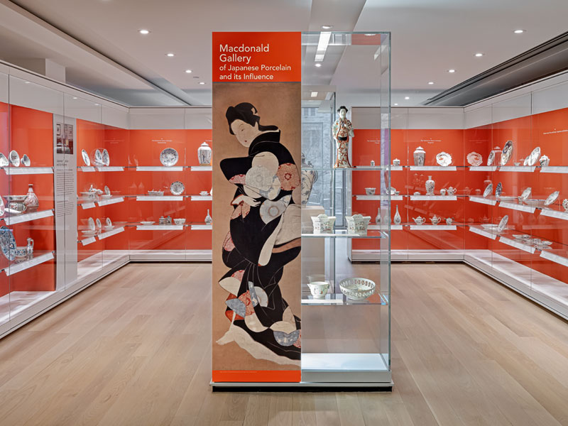 View of the Japanese porcelain gallery featuring objects in cases with an orange background