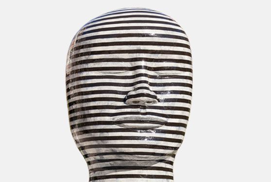 Black and silver striped ceramic sculpture of a large head