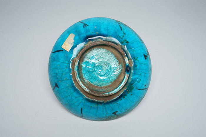 The back of a turquoise-blue dish from Iran