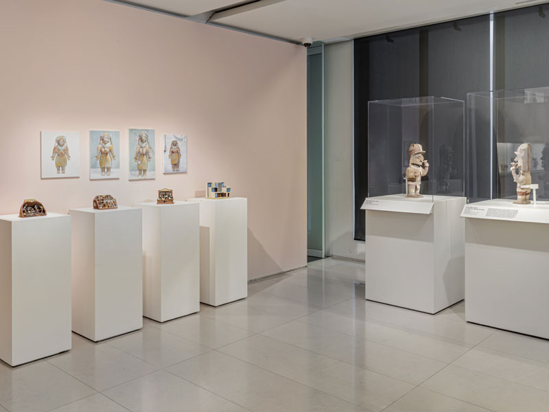 Installation view of the exhibition Replicas and Reunions with objects on plinths and a pink wall