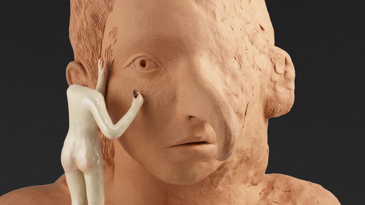 Headless figure sculpting a large clay bust