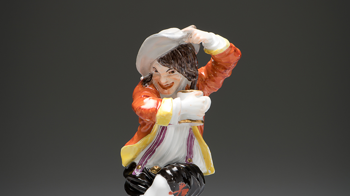 Meissen porcelain figurine wearing a hat and holding a cup