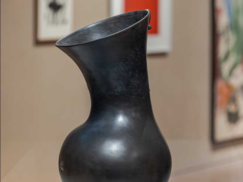 A black ceramic vessel with a wide mouth and round belly