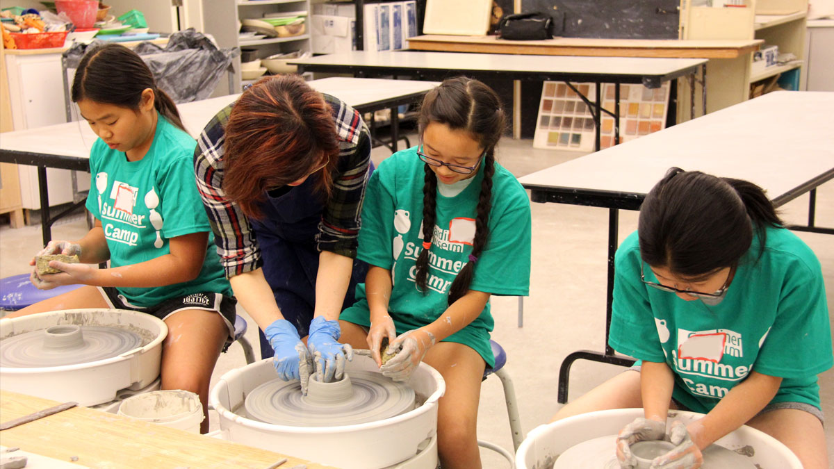 Campers working on the pottery wheel