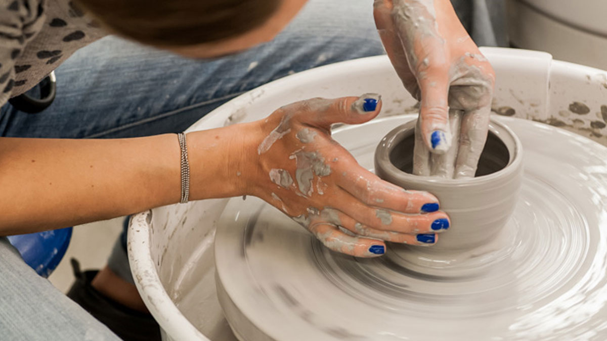 Student throwing on the pottery wheel