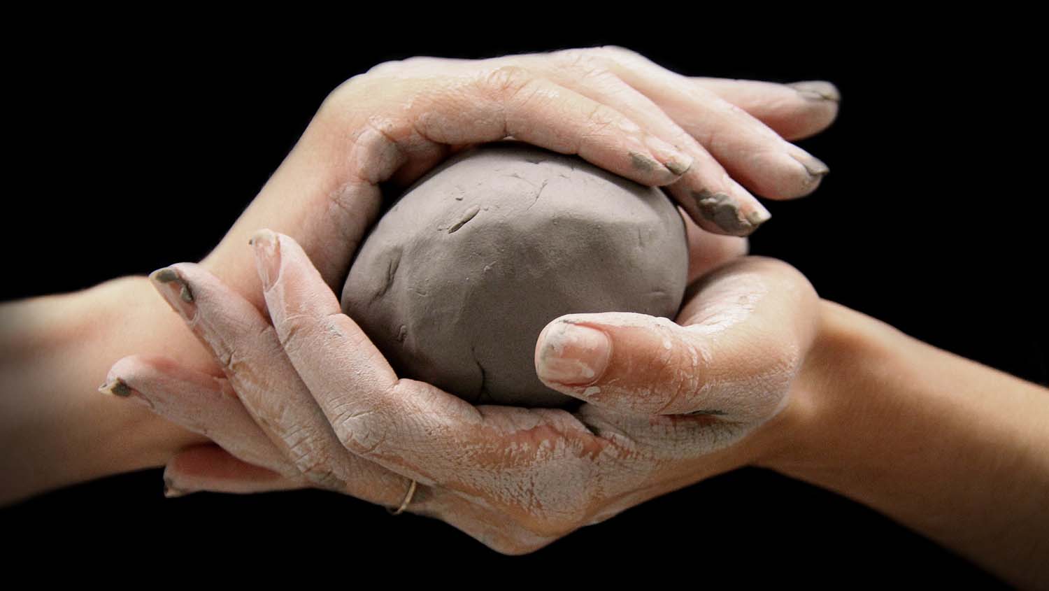 Hands holding a ball of clay