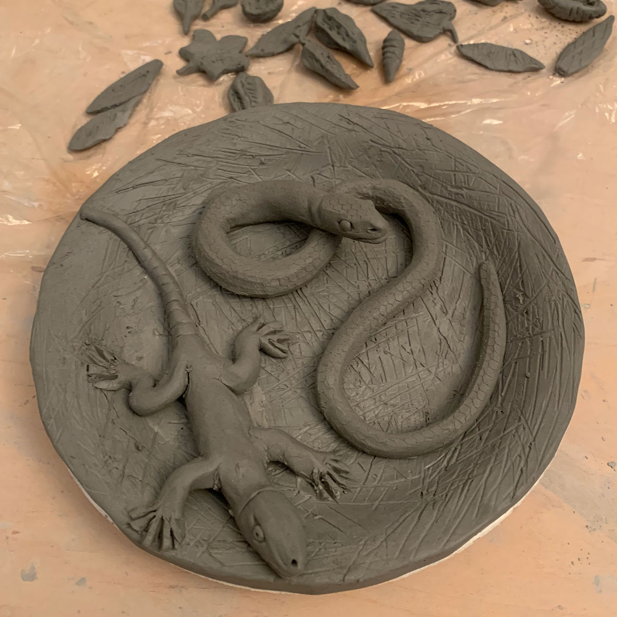 Clay lizard and snake on a clay plate